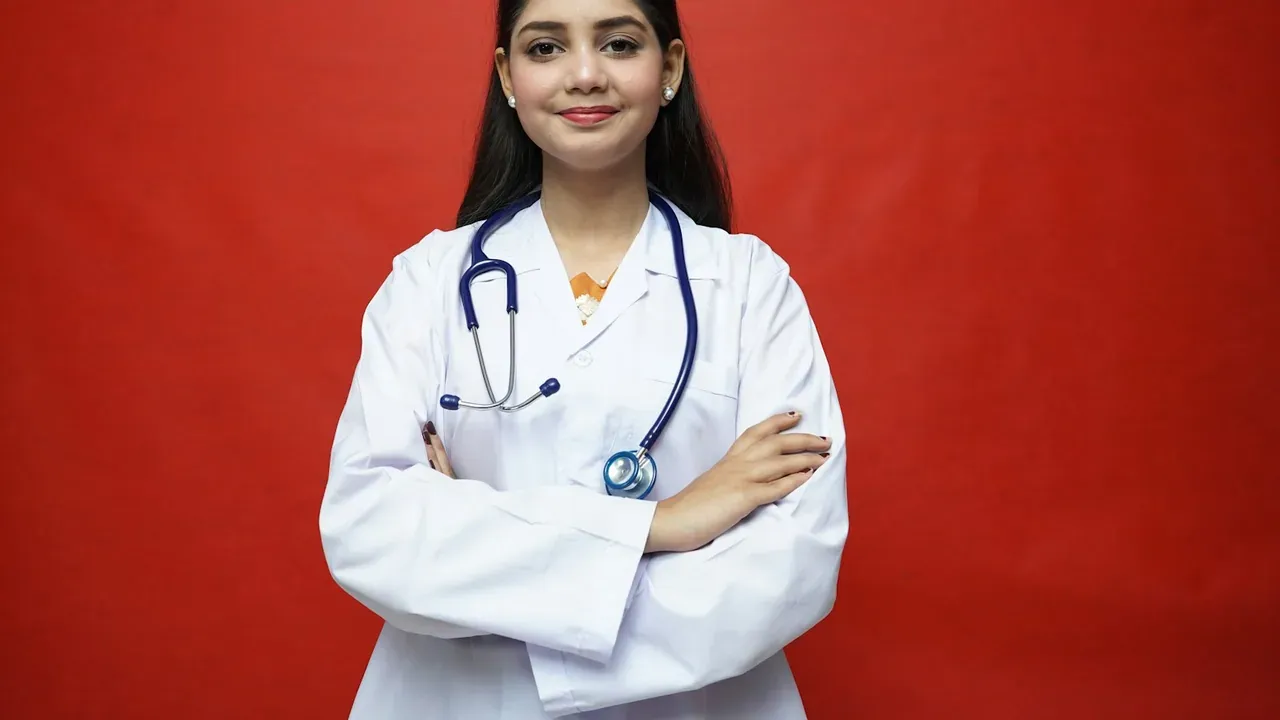 Médica de jaleco e estetoscópio, de braços cruzados
