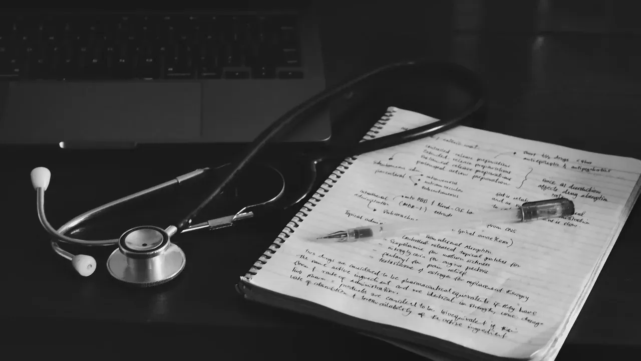Caderno, computador e estetoscópio em uma mesa de trabalho
